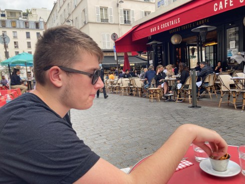 Teenager eating at cafe in Paris