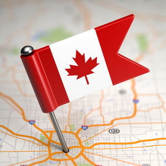 Small Flag of Canada on a Map Background with Selective Focus.